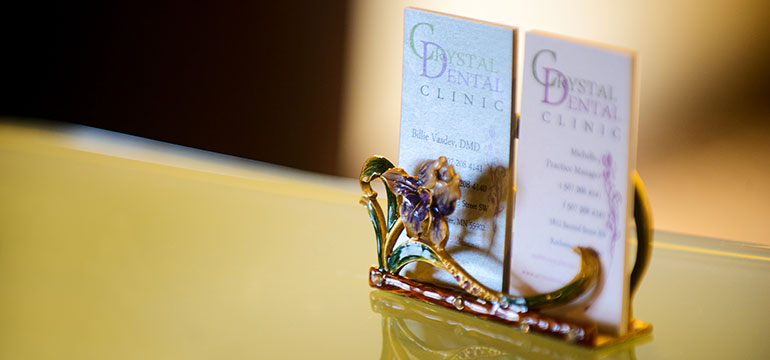 The image shows a collection of dental care items displayed on a table with a blurred background.