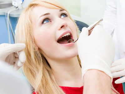A woman receiving dental care from a professional in a clinical setting.