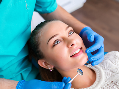 An individual receiving dental care from a professional using specialized equipment.